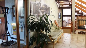 A living room with a sofa, a large potted plant, and a staircase. - Zum Goldenen Wagen (Maulburg)