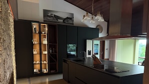Una cocina moderna con armarios oscuros, una isla central y una lámpara colgante.
