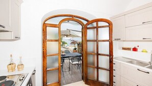 Cocina con puerta de madera que da a un patio al aire libre.