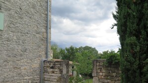 A stone building with a narrow entrance and a small garden area. - Holiday Home Augusta (Zminj)