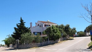 Ein zweigeschossiges Haus mit einer Steinwand und blauem Himmel.