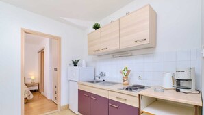 Eine kleine Küche mit Spüle, Kaffeemaschine und Schränken.