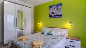 Une chambre à coucher avec un lit, des tables de chevet, une armoire et un tableau au mur.