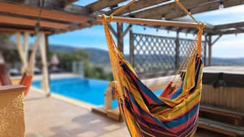 Een buitenzwembad, een verwarmd zwembad, ligstoelen bij het zwembad