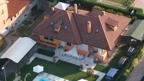 A residential house with a swimming pool, a covered patio, and a garage.