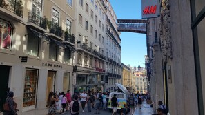 A street with multiple Zara Home stores, a H&M sign, and a busy pedestrian area.