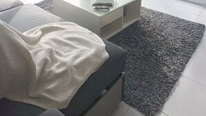 Een moderne woonkamer met een grote glazen deur die uitkomt op een zwembad.