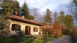 Una casa con techo de tejas, chimenea y camino de entrada pavimentado.