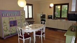Una cocina funcional con comedor, suelo de madera y ventana con cortinas.