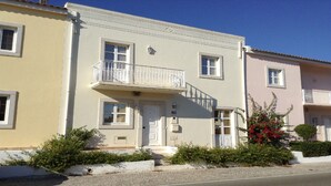 Ein zweistöckiges Gebäude mit Balkon, Tür und Fenstern.