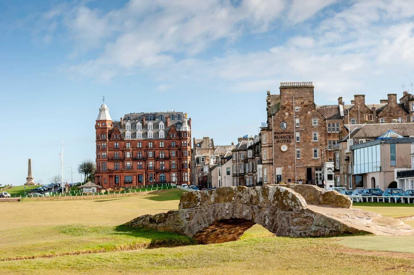 A historic building with a prominent tower and a stone bridge in the foreground.