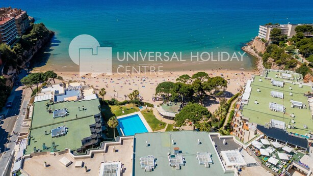 Vista aérea de un resort con piscina, playa y edificios de hotel.