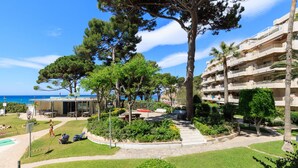 Un resort con piscina, asientos al aire libre y vista al mar.