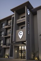 Un edificio moderno con un llamativo letrero que dice 'The Capital', que presenta un logotipo único y una entrada de vidrio.