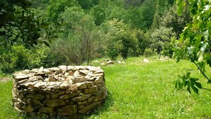 Uma construção de pedra numa paisagem verde exuberante.