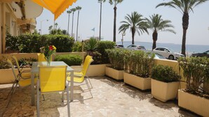 An outdoor patio with yellow chairs, a table, and potted plants. - Sea view, Beach-Front Cannes Apart, Central,  2 Bed/2 Bath,A/C,Parking, Wifi (Cannes)