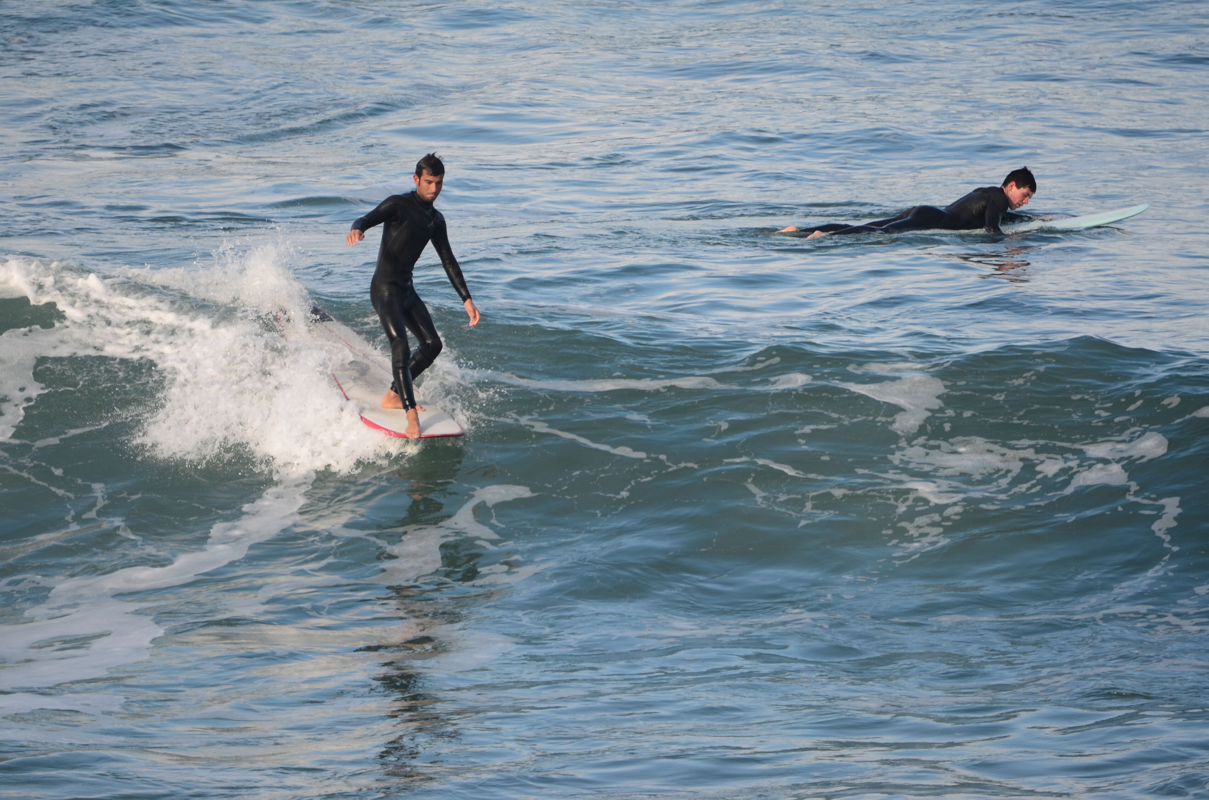 Due persone che fanno surf su un'onda nell'oceano.