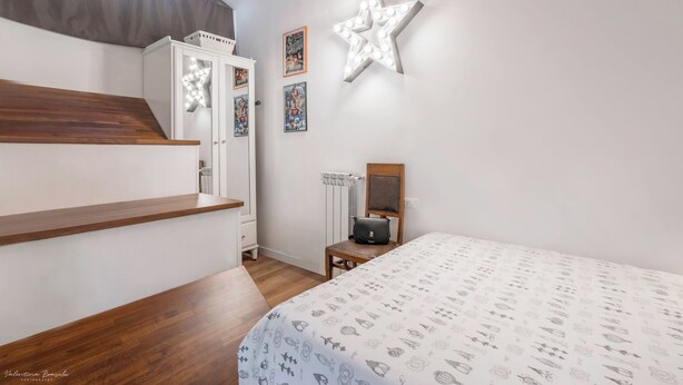 A bedroom with a bed, a star-shaped light fixture, a wardrobe, and a poster on the wall. - Loft Conversion, aircon, walk to historic centre, sleeps 4+2, parking, free Wifi (Firenze)
