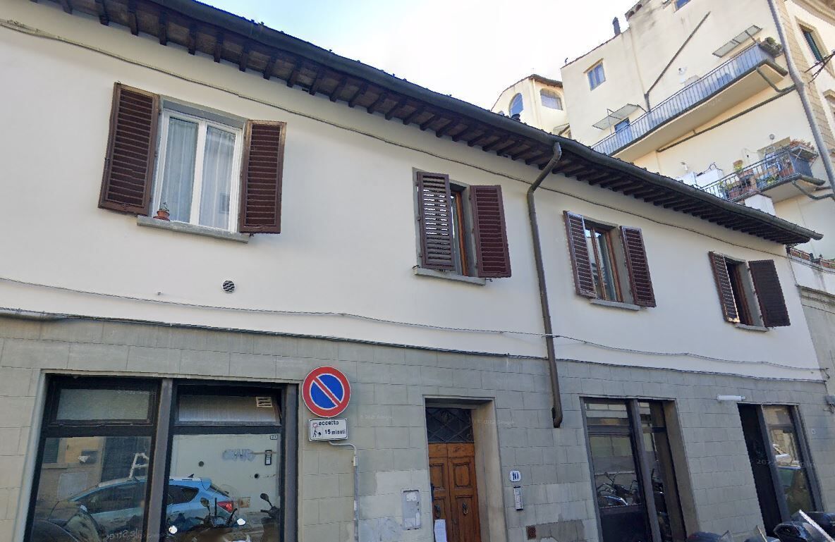Um edifício com várias janelas e uma placa de proibido estacionar.