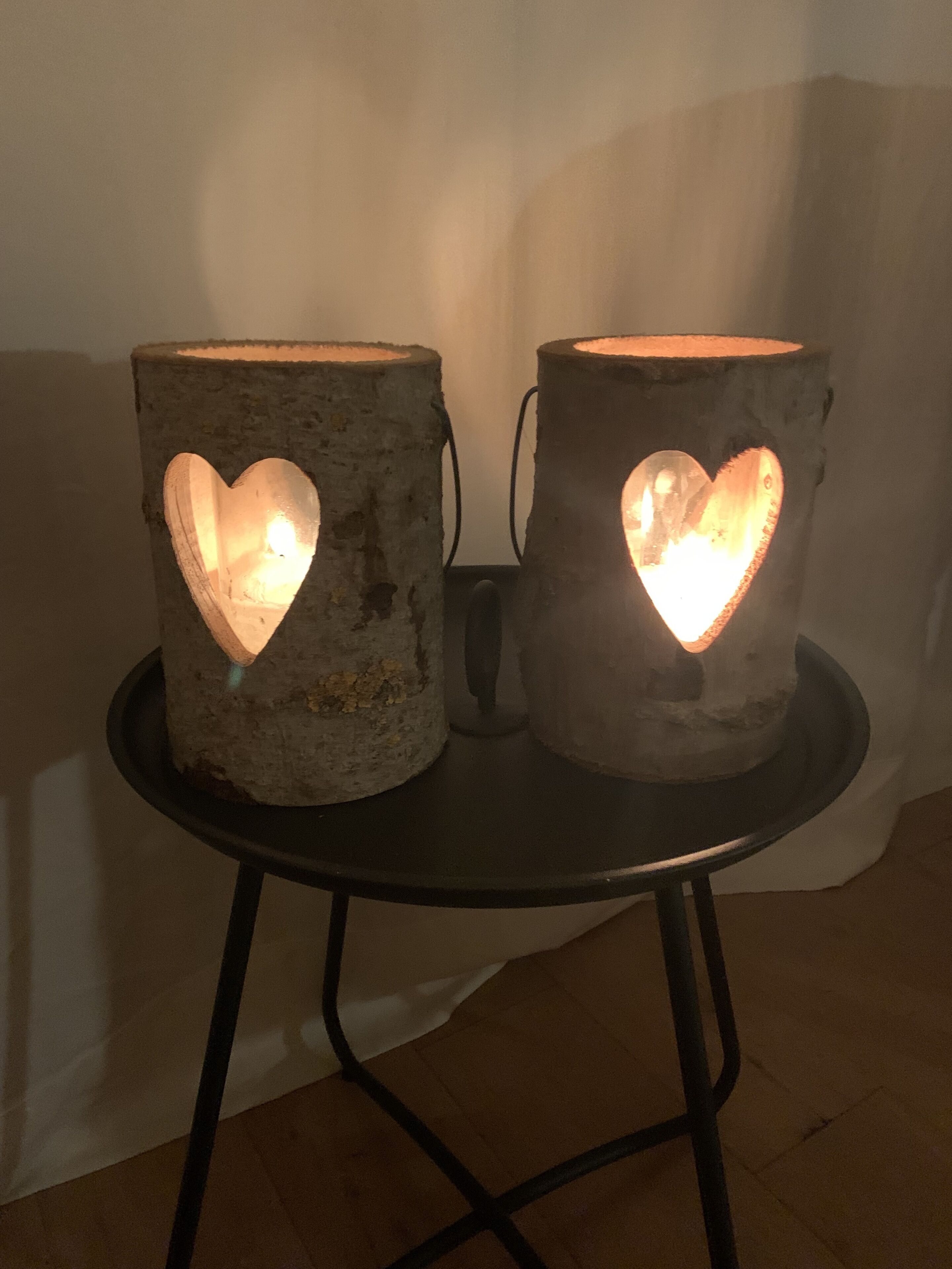 Two rustic, heart-shaped lamps on a small round table.