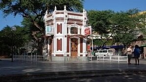 A small, ornate building with a central door and a sign above it.