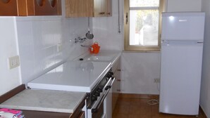 Eine Küche mit Herd, Backofen und Kühlschrank.