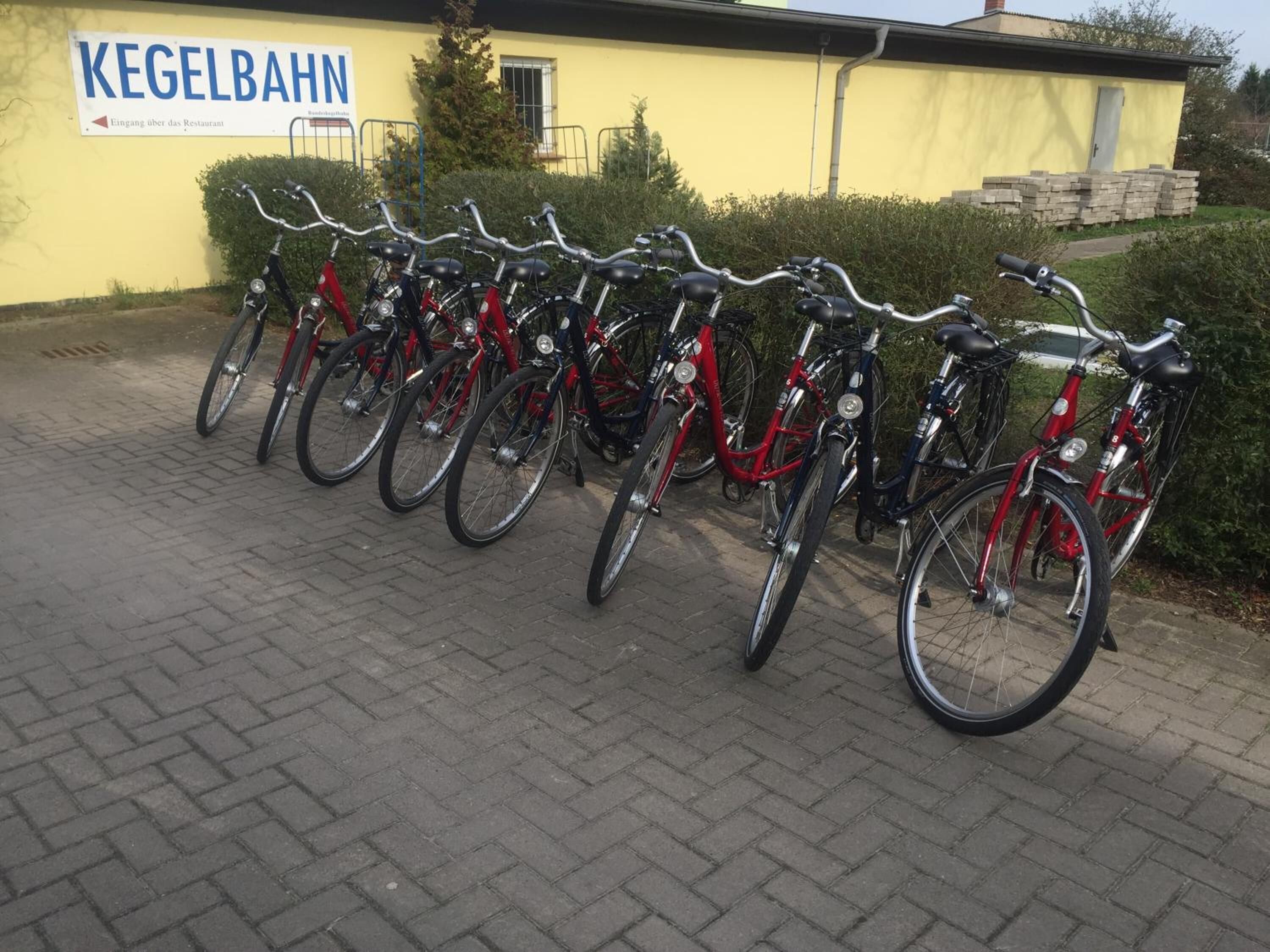 A row of bicycles parked outside a building with a sign reading "KEGELBAHN".