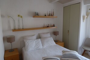 A bedroom with a bed, two nightstands, a wardrobe, and two wall-mounted shelves with decorative items. - house / villa - SAINT-CYPRIEN (Saint-Cyprien)