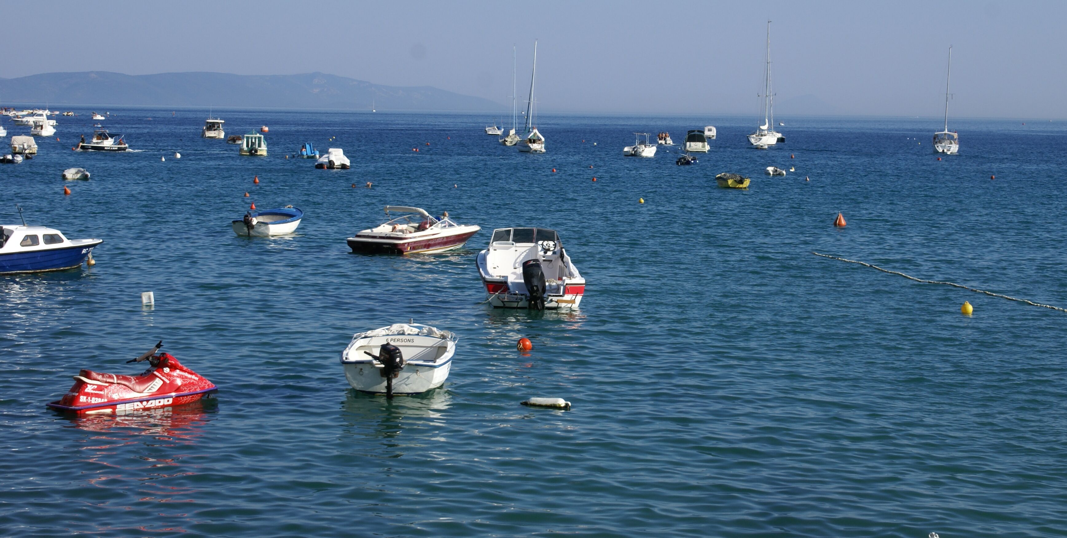 A marina with various boats anchored in calm waters.