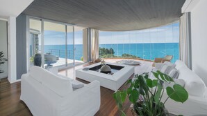 A modern living room with a white sofa, a coffee table, and a large window with a view of the sea. - House / Villa - Castiglioncello(LI) (Castiglioncello)