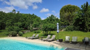 A clear blue pool with lounge chairs and a pergola.