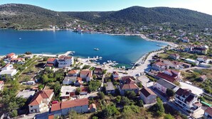 A coastal town with a marina, houses with red roofs, and a hilly backdrop. - Villa Stana (Marina)