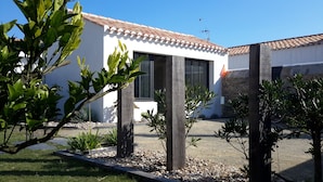 Um edifício moderno com fachada branca, janelas amplas e telhado revestido de azulejos.