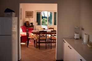A kitchen with a dining table, chairs, a refrigerator, and a blender. - House / Villa - Portoferraio (Portoferraio)