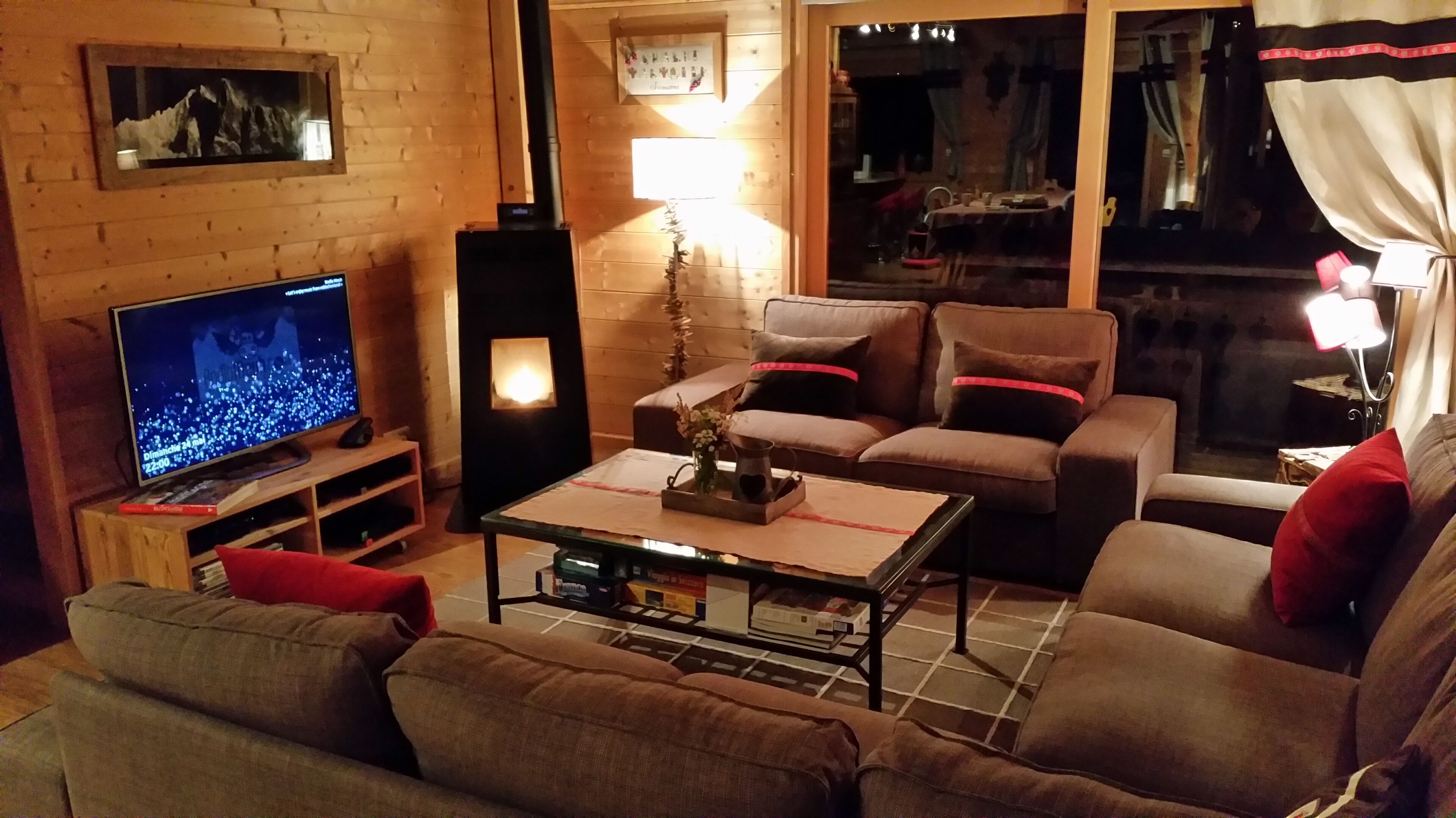 Een gezellige woonkamer met een televisie, een open haard en een bank.