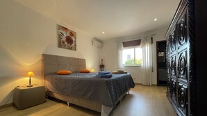 A bedroom with a bed, bedside lamps, a window with curtains, and a wardrobe. - Beautiful Villa with Relaxing Atmosphere. 4 Bedrooms, 4 Bathrooms, Large & Fenced Pool 8-10 persons (Ferreiras)