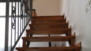 Eine Holztreppe mit Metallgeländern, die zu einer oberen Etage führt.