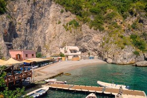 A coastal area with a dock, boats, and a building with a sloped roof.