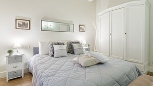 Une chambre à coucher comprenant un lit, des tables de chevet, une armoire et des éléments de décoration fixés au mur.