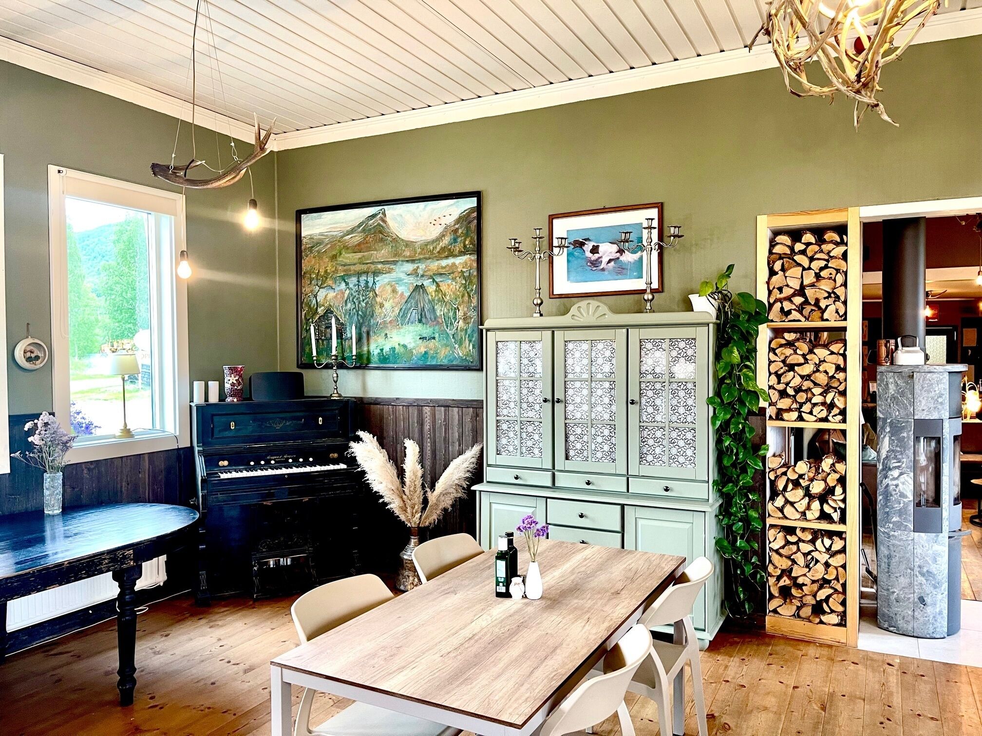 Un comedor acogedor con un piano, un cuadro y una chimenea.