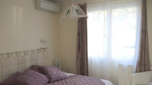 A bedroom with a bed, a bedside table, a chair, and a window with curtains. - Comfortable Villa Close to Lake Sea Mountains Airport Unrivaled View  (Prades)