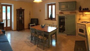 Ein Essbereich mit einem Holztisch, Stühlen, einem Fernseher und einem Schrank mit Geschirr.