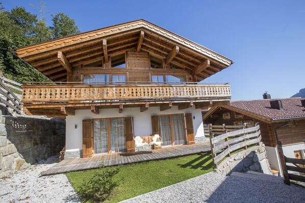 Een chalet met een houten balkon, stenen muren en een schuin dak.