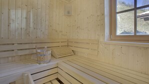 Una sauna amb seients de fusta i una finestra.