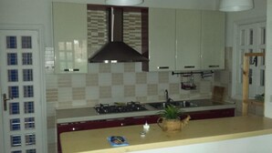 A kitchen with a central island, a stove, and a hanging pot rack.