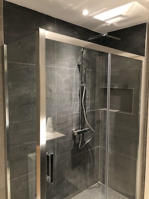 Een bad/douchecombinatie, een haardroger, een bidet, handdoeken