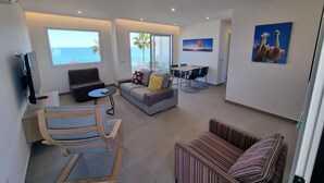 Una sala de estar moderna con un sofá, una mesa de comedor y un televisor.