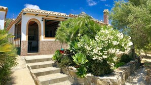 A house with a stone facade, a tiled roof, and a staircase leading to the entrance. - House with barbecue and fireplace, ideal for summer and winter. (Bolonia)