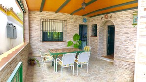 A patio with a stone table and chairs, a potted plant, and a sign reading "TORAMOTO DE MARA." - House with barbecue and fireplace, ideal for summer and winter. (Bolonia)