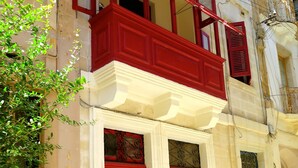 A two-story building with red doors and a balcony.